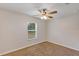 Cozy bedroom with ceiling fan, neutral carpet, and a window providing natural light at 12 Pecan Drive Loop, Ocala, FL 34472