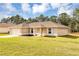 Inviting single-story home featuring a well-maintained lawn and an attached garage at 12 Pecan Drive Loop, Ocala, FL 34472