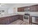 Bright kitchen with stainless steel appliances, granite countertops, and wood-look flooring at 12 Pecan Drive Loop, Ocala, FL 34472