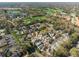 An aerial view of a residential community with mature trees and lush green golf course in the background at 1416 Creekside Cir, Winter Springs, FL 32708