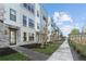 Modern townhome exterior with brick accents, sidewalk, landscaping, and community pergola at 2225 Valentine Aly, Orlando, FL 32804