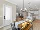 Dining area leading to a living room and kitchen, with a wooden table and modern seating at 234 Hammock Preserve Loop, Winter Garden, FL 34787