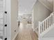 Open hallway featuring hardwood floors, a staircase with carpet, and an arched view into the living room at 234 Hammock Preserve Loop, Winter Garden, FL 34787