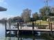 Waterfront home featuring a private dock with boat, clear water, and lush landscape, perfect for outdoor living at 2500 Lee Rd # 202, Winter Park, FL 32789