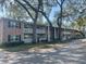 Low-angle view of a multi-unit building featuring private balconies and mature tree coverage at 2500 Lee Rd # 202, Winter Park, FL 32789