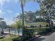 Building exterior featuring a well-maintained community pool and lush landscaping at 2500 Lee Rd # 202, Winter Park, FL 32789