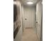 Well-lit hallway with tiled flooring, white doors, and modern artwork at 2500 Lee Rd # 202, Winter Park, FL 32789
