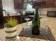 Close-up of a kitchen counter with wine glasses, a bottle, and a decorative plant at 2500 Lee Rd # 202, Winter Park, FL 32789