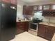 Well-equipped kitchen with dark wood cabinets, stainless steel appliances, and granite countertops at 2500 Lee Rd # 202, Winter Park, FL 32789