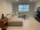 Bright living room featuring a neutral sectional sofa and tile floors at 2500 Lee Rd # 202, Winter Park, FL 32789