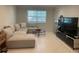Bright living room featuring a large sectional sofa, round table, and a modern media center at 2500 Lee Rd # 202, Winter Park, FL 32789