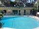 Community pool area featuring a pool house, lounge chairs, and well maintained water at 2500 Lee Rd # 202, Winter Park, FL 32789