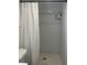 White subway tile shower with toiletry shelf and shower curtain at 2500 Lee Rd # 202, Winter Park, FL 32789