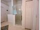 Bright bathroom with a glass door shower, white walls, and a white tile shower at 2609 Summer Creek Dr, Kissimmee, FL 34747