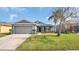 Charming single-story home with a well-manicured lawn and attached garage, complemented by lush landscaping at 2783 Trommel Way, Sanford, FL 32771
