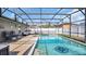 Relaxing screened-in pool with lounge seating, umbrella, and lush landscaping at 2783 Trommel Way, Sanford, FL 32771