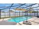Backyard pool area with a screened enclosure and a relaxing lounge space at 2783 Trommel Way, Sanford, FL 32771