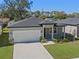 Single-story house with a white garage door and a neatly landscaped yard at 2896 Lingo Ln, Orlando, FL 32822