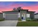 House exterior at dusk showcasing a neutral color scheme and a well-maintained lawn at 2896 Lingo Ln, Orlando, FL 32822