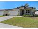 One-story home with a white garage door, landscaped lawn, and a covered entryway at 2896 Lingo Ln, Orlando, FL 32822