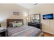Cozy bedroom with striped bedding, dresser, and TV at 3071 Beach Palm Ave, Kissimmee, FL 34747
