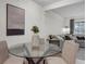 Stylish dining area with a glass table, seating for four and view into the living room at 3104 Harrison Ave # 11, Orlando, FL 32804