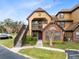 Two-story condo building with brick and siding exterior, stairs, and landscaping at 430 Forestway Cir # 105, Altamonte Springs, FL 32701