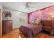 Bedroom with hardwood floors, large mural, and dresser at 5800 N Dean Rd, Orlando, FL 32817