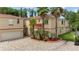 Spacious two-story house with an attached garage, brick paved driveway, and lush tropical landscaping at 5800 N Dean Rd, Orlando, FL 32817