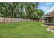 Spacious backyard featuring a large lawn area, wooden fence, and screened-in porch at 605 Marni Dr, Winter Springs, FL 32708