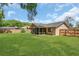 Large backyard with a well-maintained lawn, a screened in porch, and a sturdy wooden fence at 605 Marni Dr, Winter Springs, FL 32708