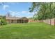 Scenic view of the home's backyard, featuring a well kept lawn, screened in patio, and a wooden fence at 605 Marni Dr, Winter Springs, FL 32708