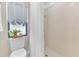 Bright bathroom featuring a tile shower, toilet, and window with elegant decor at 605 Marni Dr, Winter Springs, FL 32708
