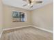 A bedroom with hardwood floors, tan walls, ceiling fan, and a large window at 605 Marni Dr, Winter Springs, FL 32708