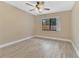 Bedroom with hardwood floors, tan walls, ceiling fan, and a large window at 605 Marni Dr, Winter Springs, FL 32708