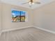 A bedroom with hardwood floors, tan walls, ceiling fan, and a large window at 605 Marni Dr, Winter Springs, FL 32708