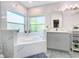 Bright bathroom with a tub, a large window, and marble finishes at 8130 Yellow Crane Dr, Kissimmee, FL 34747