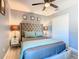 This bedroom offers a tufted headboard, ceiling fan and matching night stands at 8130 Yellow Crane Dr, Kissimmee, FL 34747