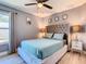 This bedroom offers a tufted headboard, wood floors, and a ceiling fan at 8130 Yellow Crane Dr, Kissimmee, FL 34747