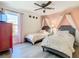 Charming bedroom featuring two twin beds with crown canopies and a ceiling fan at 8130 Yellow Crane Dr, Kissimmee, FL 34747