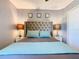 The primary bedroom features decorative art, tufted headboard, and wood floors at 8130 Yellow Crane Dr, Kissimmee, FL 34747
