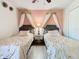 Twin beds with crown canopies and a nightstand in this bedroom at 8130 Yellow Crane Dr, Kissimmee, FL 34747