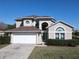 Charming two-story home featuring a manicured lawn and an attached two-car garage at 8130 Yellow Crane Dr, Kissimmee, FL 34747