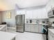 Bright kitchen featuring stainless steel appliances, white cabinets, and modern countertops at 8130 Yellow Crane Dr, Kissimmee, FL 34747
