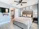 The primary bedroom showcases a wall mounted TV, ceiling fan, and light wood floors at 8130 Yellow Crane Dr, Kissimmee, FL 34747