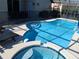 A beautiful backyard pool and spa area features a -safe fence and tanning ledge at 8130 Yellow Crane Dr, Kissimmee, FL 34747