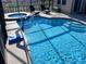 Enclosed pool area features clear blue water, integrated spa, sun loungers and basketball hoop at 8130 Yellow Crane Dr, Kissimmee, FL 34747