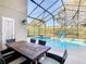 Covered patio area with a dining table that overlooks a pool at 8130 Yellow Crane Dr, Kissimmee, FL 34747