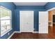 Bedroom showcasing modern blue walls with a large window and closet for ample storage at 933 Southern Oak Ln, Apopka, FL 32712