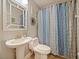 Bathroom with pedestal sink, updated fixtures, contemporary mirror, and decorative shower curtain at 980 Mooring Ave # 103, Altamonte Springs, FL 32714